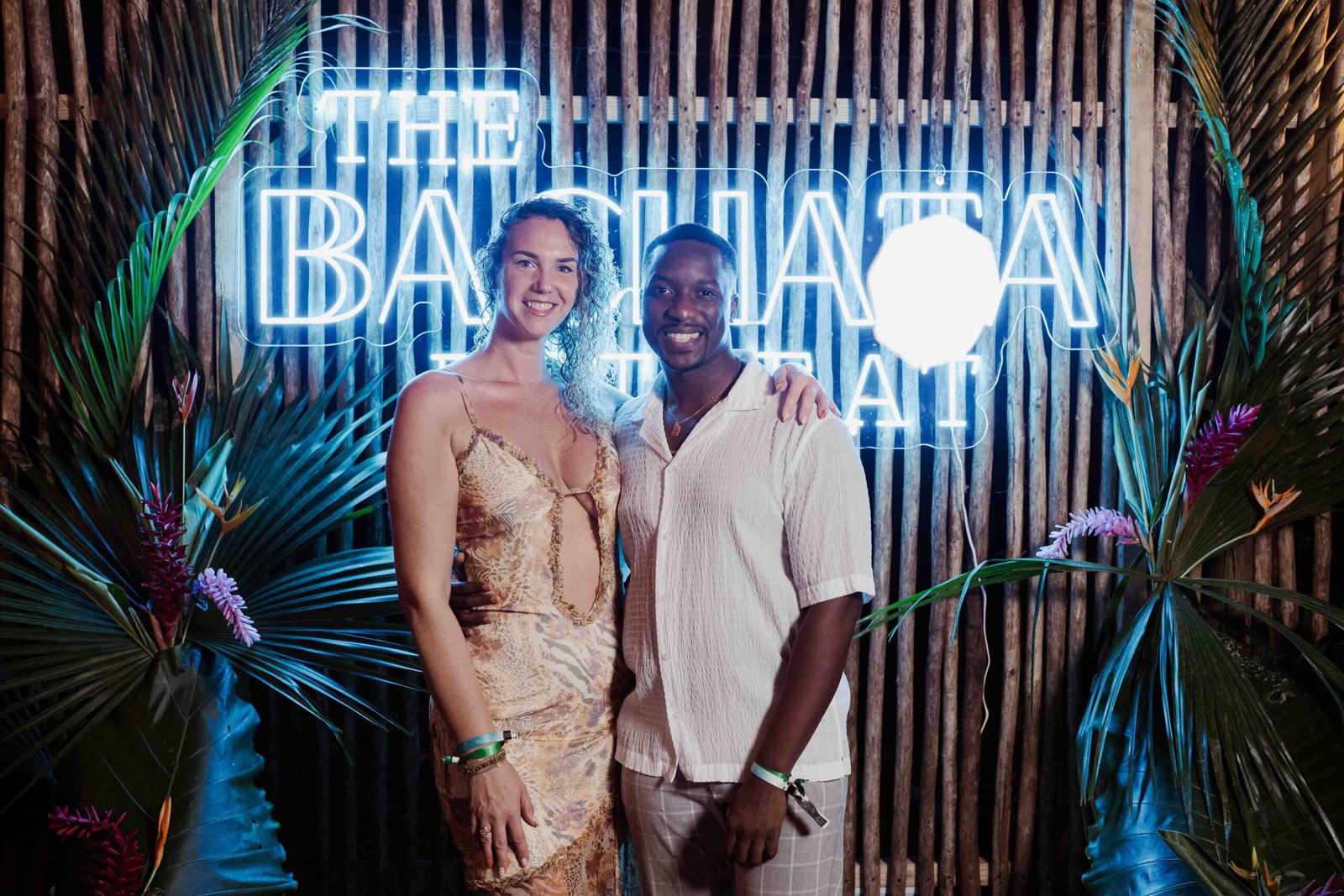 Claudio, Santo Domingo Experience testimonial, posing in front of a Bachata neon sign
